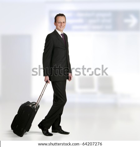 Portrait of a successful businessman walking through airport with travel bag