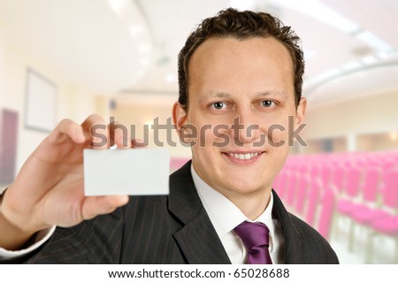 Successful businessman or business trainer holds a business card.