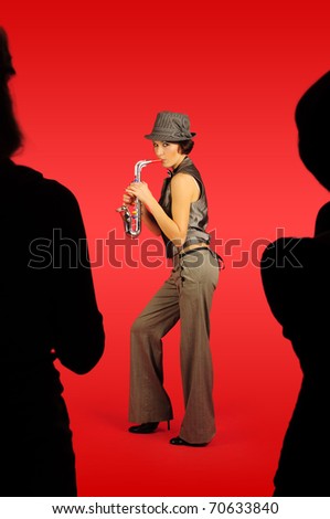 Woman with saxophone between two silhouettes on red background.