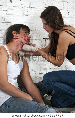 Young woman and beaten man after fight sitting on the floor