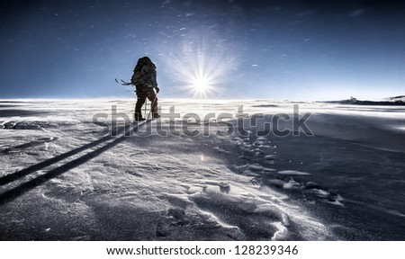 Climber fights with bad weather in the winter mountains