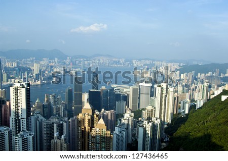 Luxury hilltop looking out over the dramatic night time neon lights and illuminated skyscrapers, crowded high-rise apartment blocks and futuristic architecture of Hong Kong Island from Victoria Peak