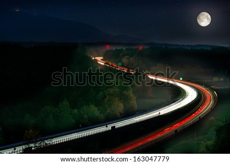 Long Exposure of Car Lights on Motorway Car Lights on Motorway with Moon, stars and green forrest