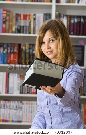 Young woman stretches big black book