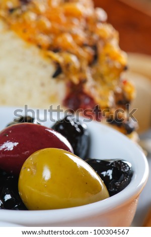 Appetizer platter with bread, cheese, meat, olives, and oil and vinegar.