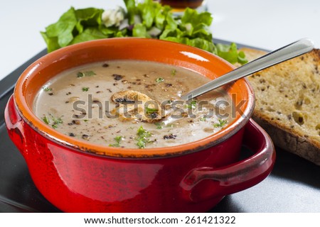 Creamy wild mushroom soup diner with garlic toast, lettuce salad, and a beer.