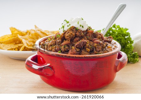 Spicy Beef and bean mexican chili with nacho chips and sour cream