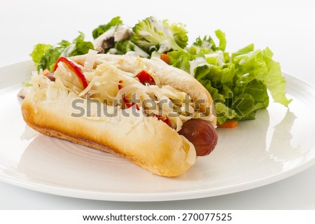 Grilled Hot Dog with sauerkraut and hot red peppers, with side salad