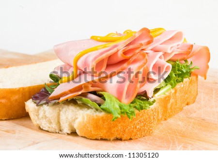 Ham Sandwich with pickles tomatoes lettuce, mayonnaise, and white cheddar on French bread