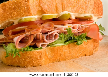 Ham Sandwich with pickles tomatoes lettuce, mayonnaise, and white cheddar on French bread