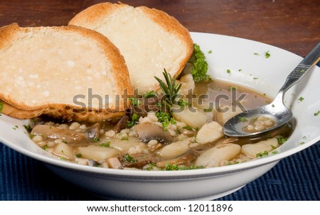 Bowl of beef and barley soup with cheese toast