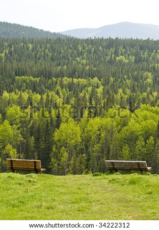 Park benches overlooking a forest in the mountains