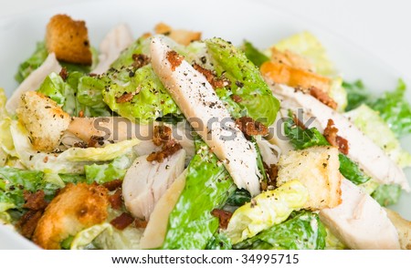 Bowl of chicken Caesar salad, on white