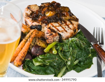 Grilled pork chop with roasted vegetables, swiss chard, and balsamic vinegar and cherry sauce