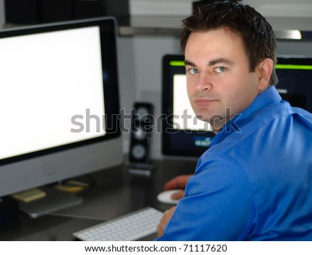 Single man in  business attire working at a computer