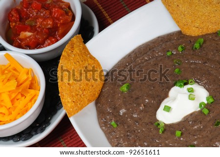 Black Bean Soup with Nacho Chips, sour cream, green onions, cheddar cheese, and salsa