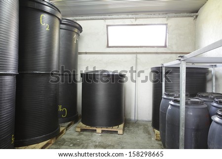 Black barrels made of industrial, alimentary, plastic used for keeping alcohol