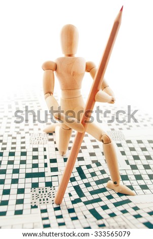 Classic wooden dummy with red pencil and crossword puzzles.