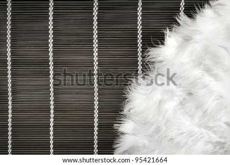 Art background of feather fan on a wooden mat.