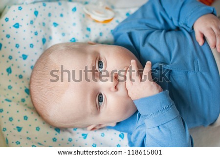 Adorable baby boy with blue eyes in blue clothes
