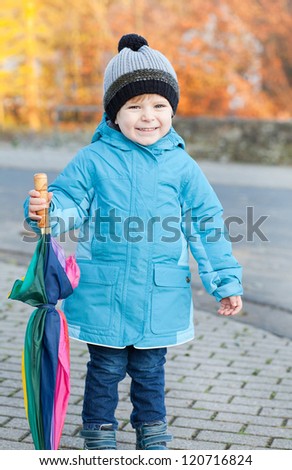 Beautiful toddler boy in blue clothes dreaming on sunny winter day