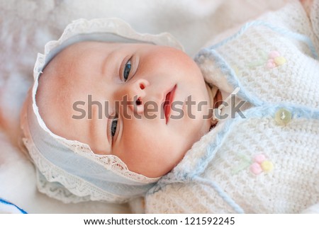 Little newborn baby boy one month old in self made clothes