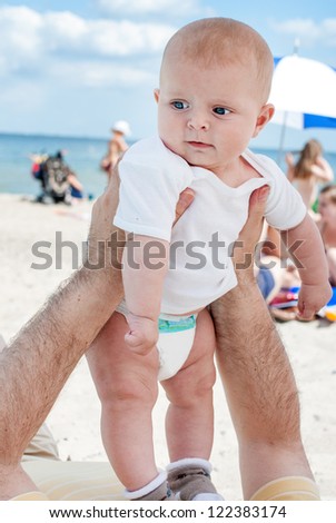 Lovely baby boy outdoor on North sea beach on warm summer day