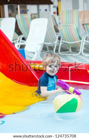 Activities on the pool, toddler boy swimming, having fun and playing in water, indoor