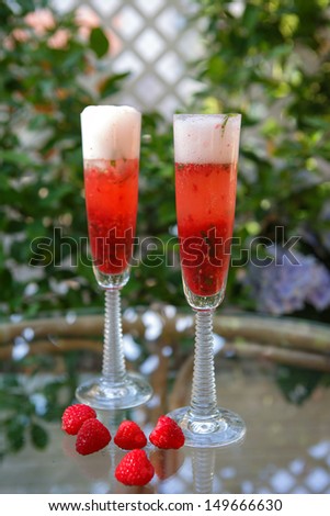 Summer cocktail with champagne, peppermint and fresh raspberries