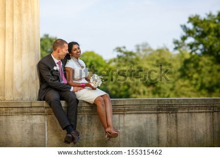 Beautiful indian bride and caucasian groom, in summer park