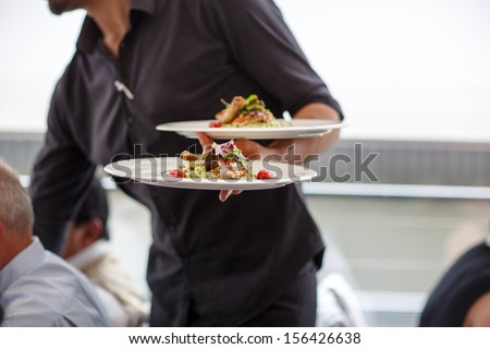 Waiter Carrying A Plate With Salad Dish On A Wedding
