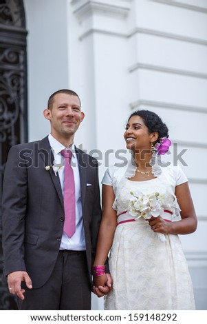 Happy couple in love: Beautiful indian bride and caucasian groom, after wedding ceremony
