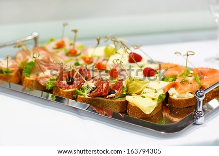 Different tasty snacks as finger food on luxury banquet table .
