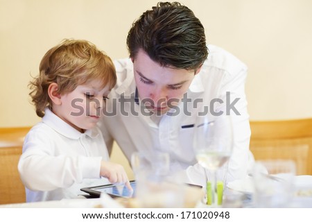 Little boy playing with his older brother with tablet pc, indoor