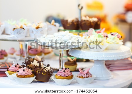 Elegant sweet table with cupcakes, cake pops and candy on dinner or event party