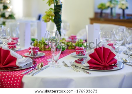 Elegant table set  for wedding or event party in pink with dots: glasses, napkins, flowers