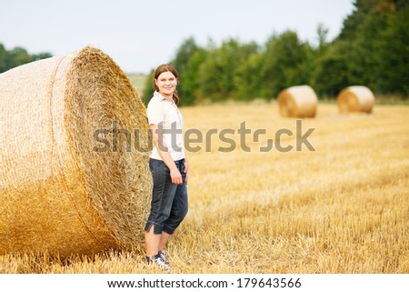 Young beautiful woman on yellow golden hay field, Germany.