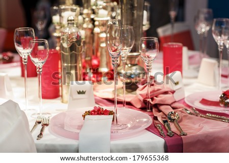 Elegant table set in soft red and pink for wedding or event party