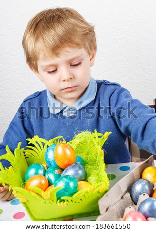 Little toddler boy being happy about Easter egg hunt, traditional action in Germany for Eastern holiday