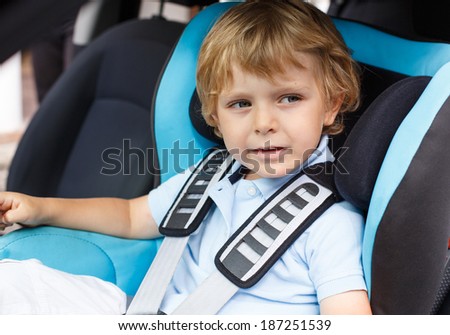 Little boy of 3 years sitting in safety car seat
