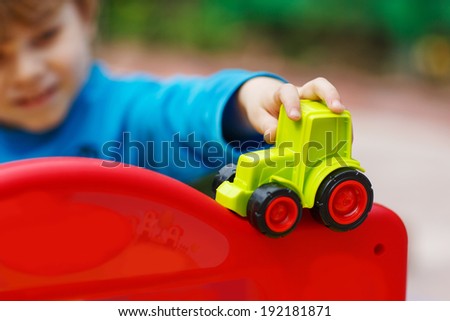 Little toddler boy playing with car toy. Selective focus on hand of toddler and toy