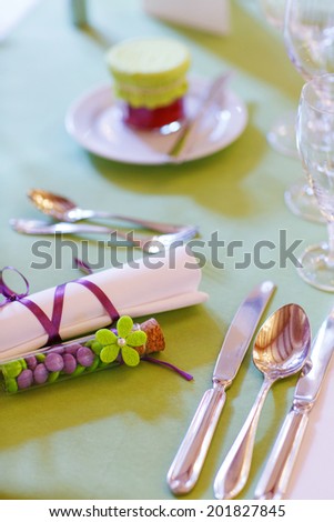 Elegant table set in lilac and green for wedding or event party, with give away for guests