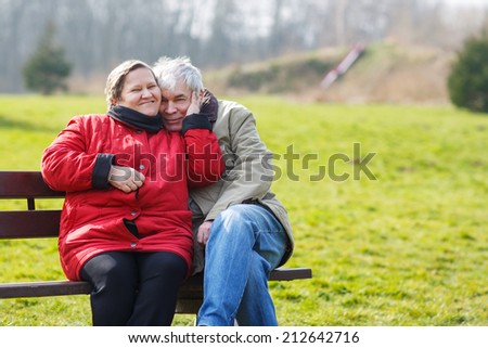 Happy senior couple in love. Park outdoors. in spring on cold day