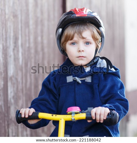 Active little child riding bicycle in village or city. Square format.