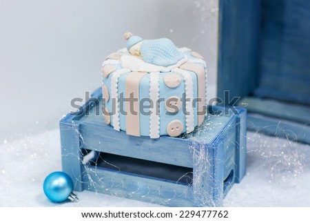 Baby birthday cake in soft blue and white, as gift for birth or christening party.