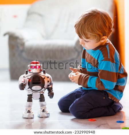 Funny cute little child playing with robot toy at home, indoor. Square format.