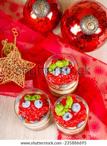 Christmas dessert: Sweet dessert tiramisu with strawberry, fresh blueberries and basil. Healthy food for guests. Decorated with Christmas balls and star.