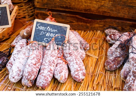 French saucissons and ham display in market in south of France, Arles, Provence. Local organic food.