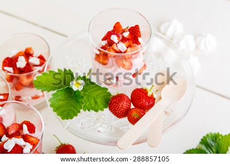 Summer dessert: strawberry with yoghurt cream and meringue in glass. Healthy organic and vegan food.