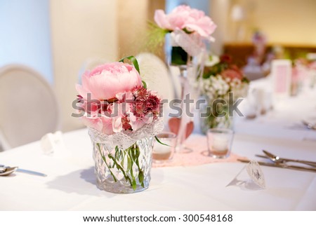 Table set in soft pink and white for wedding or event party. Luxury decoration for celebration, with give away for guests